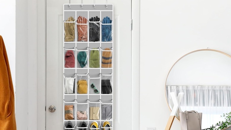 Clear over-the-door shoe hanger displaying gloves, hats, wallets, and sunglasses