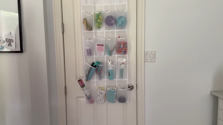 Collection of craft supplies organized into the pouches of a shoe holder