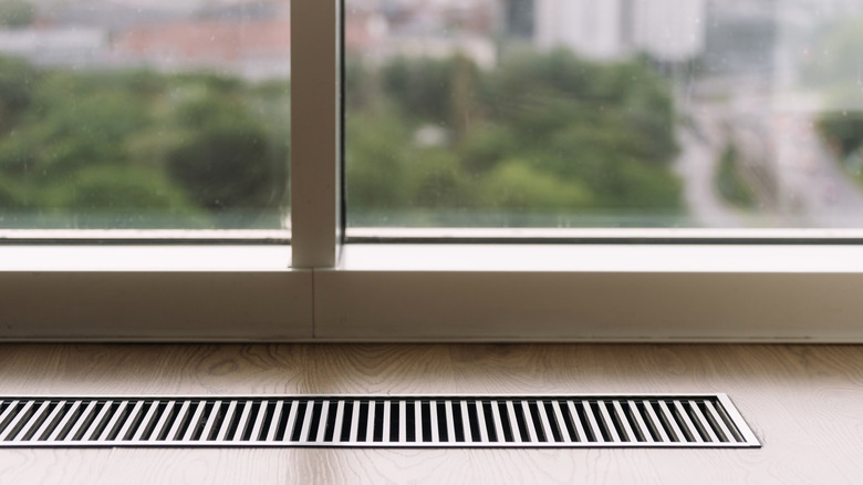 A vent cover on a wooden floor