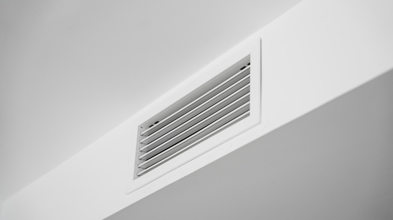 A white vent cover blends in with the white paint of the wall behind