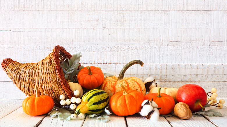 Cornucopia holding fall produce