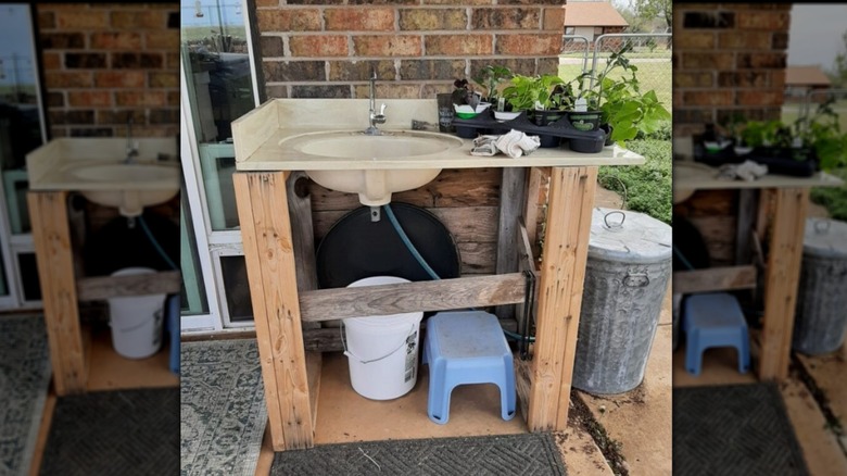 A bathroom sink installed on wooden bars outdoors