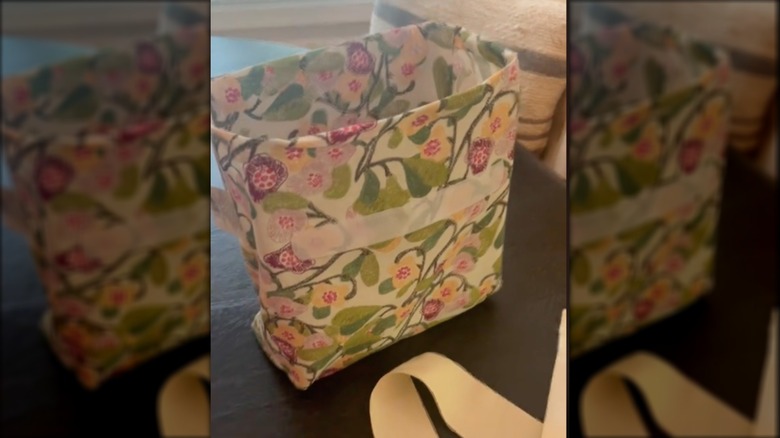 A bed sheet bag with velcro is standing up on ts own thanks to its cardboard insert.