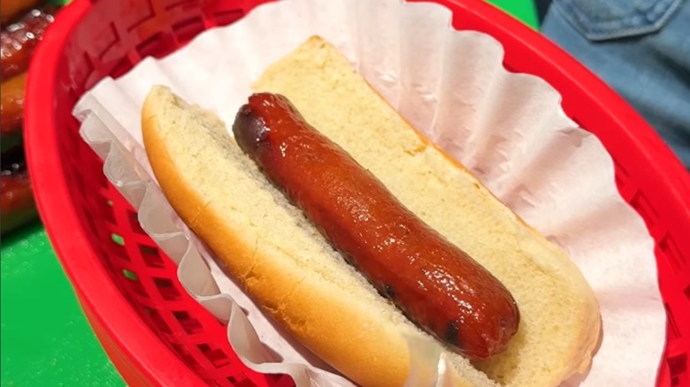 A red food basket with a filter lining holding a hotdog.