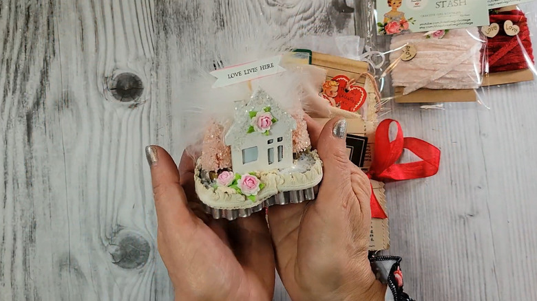 Person holding a Valentine's-themed diorama created in a heart-shaped metal cookie cutter