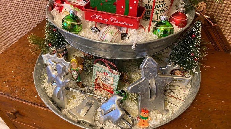 Decorative tiered tray with holiday items, including several vintage cookie cutters