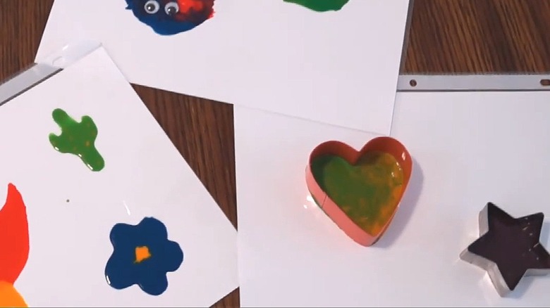 Gel clings drying on plastic sheets with a heart and star cookie cutter around the glue mixture