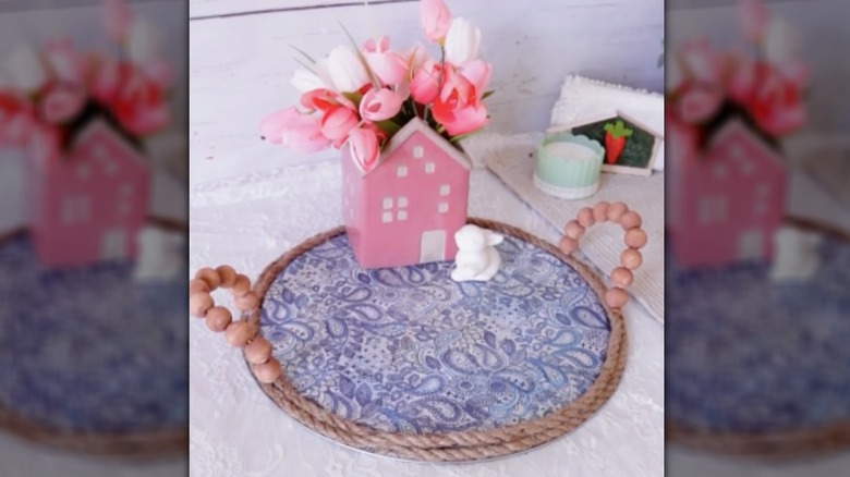A tray is decoupaged in a purple paisley paper and holds some decorative spring objects