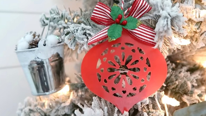 A red ornament on made from Dollar Tree chopping mat on imitation snow-covered tree