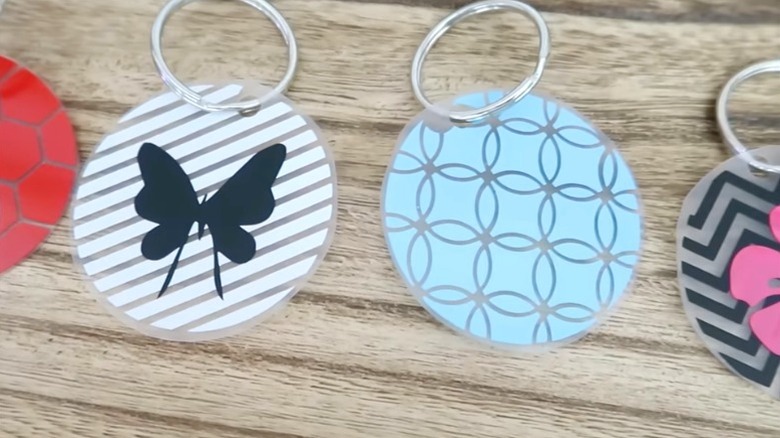 DIY key ring tags made from Dollar Tree chopping mats lying on wood surface