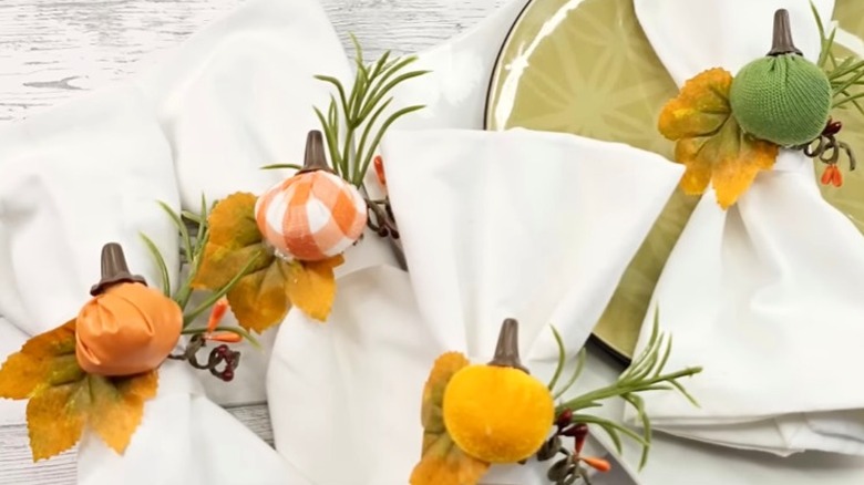 Fall-themed napkin holders wrapped around white napkins
