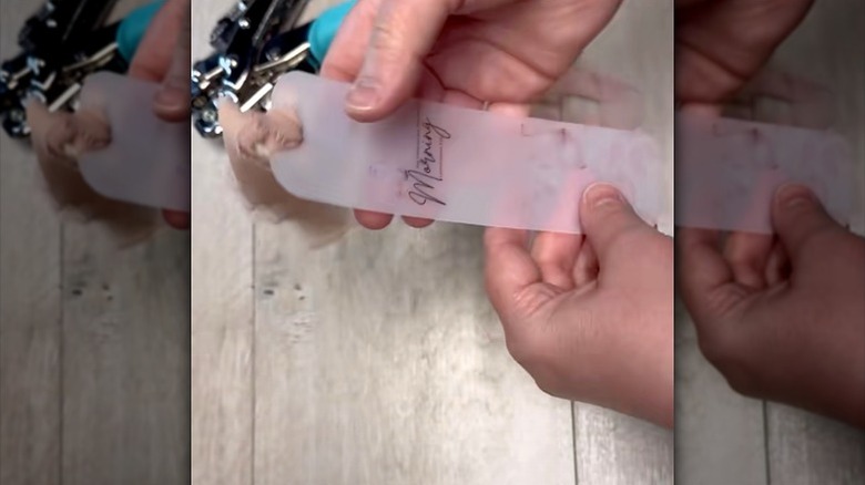 A person holding DIY bookmark made from Dollar Tree chopping mat