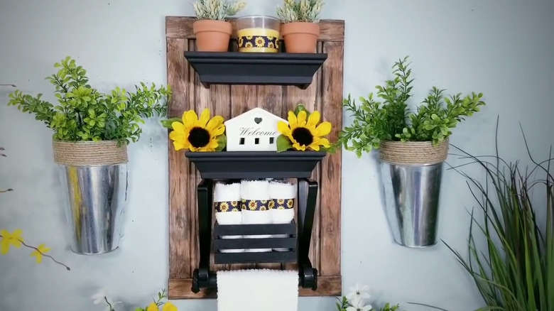 Stained wood towel holder decorated with miniature house and sunflowers