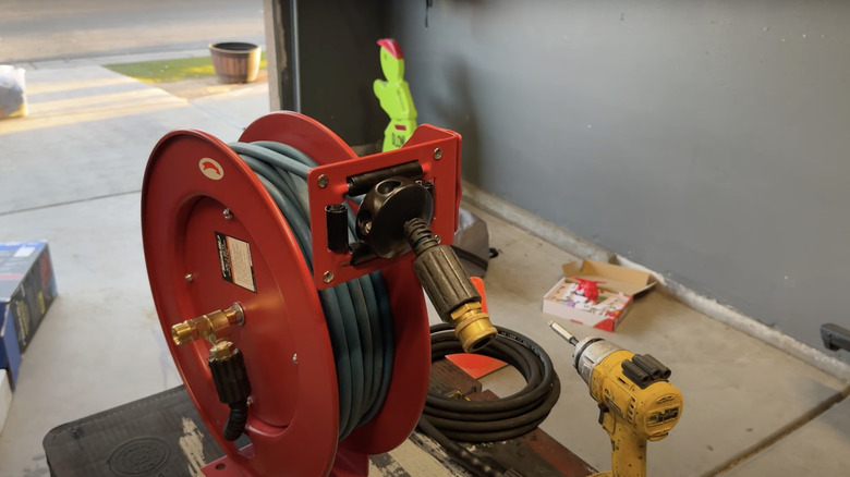 A metal garden hose reel has been converted to a pressure washer hose reel.