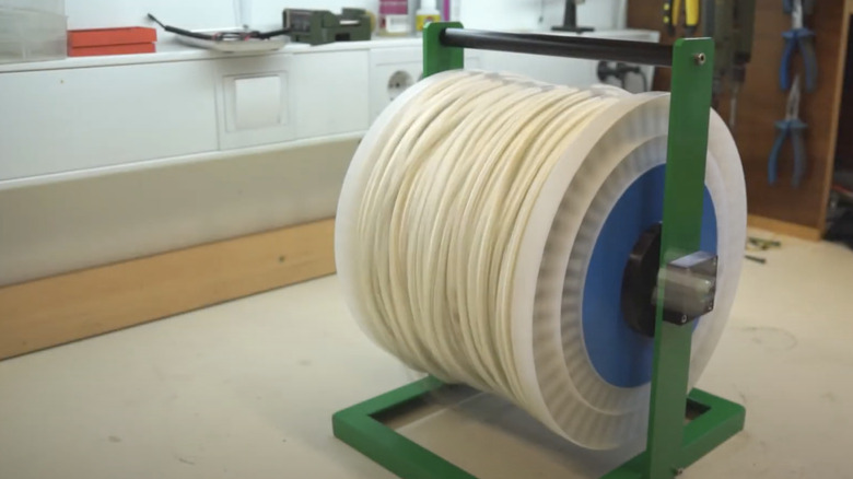 Rope wrapped around the spool from an old garden hose reel and set into a DIY stand.