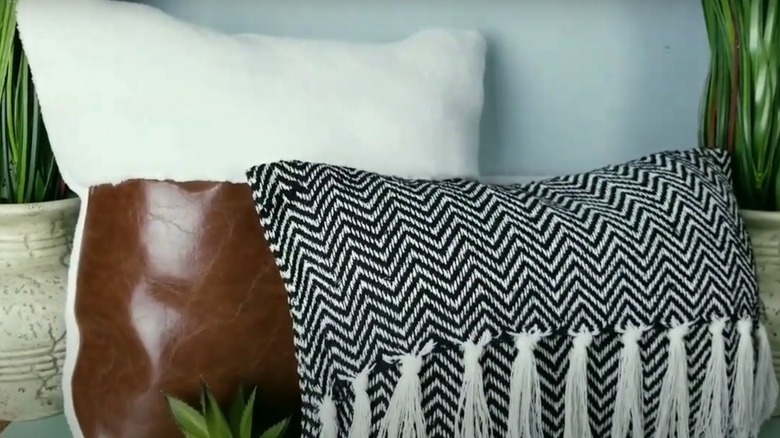 A cushion cover made from imitation leather, microfiber cloth, and decorative fringe
