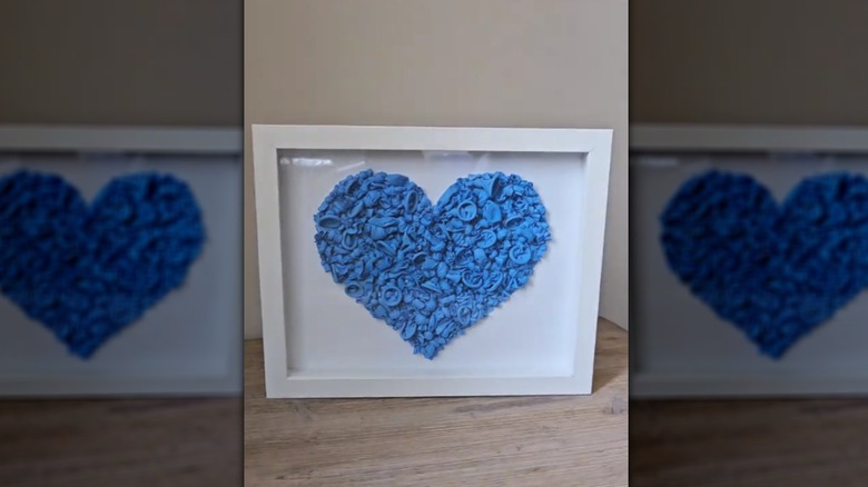 Picture frame with blue deflated balloons formed into a heart