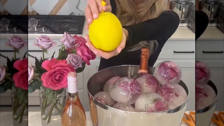 Person holding a large ice cube next to a bowl of large ice cubes all made from balloons