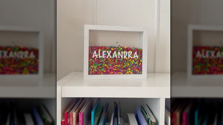 Frame full of chopped balloon confetti on a bookshelf