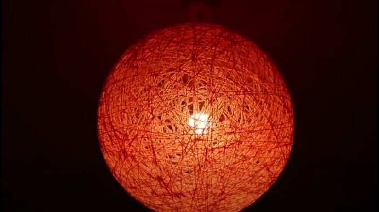 Orange lampshade made from yarn that was wrapped around a balloon to make it