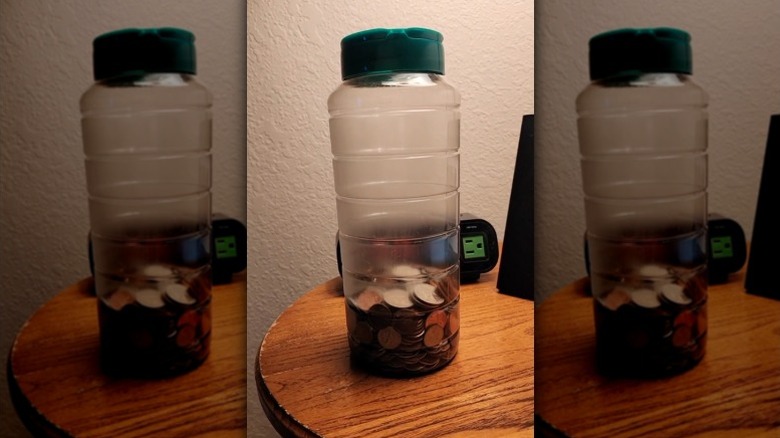 An old parmesan cheese jar filled with spare change.
