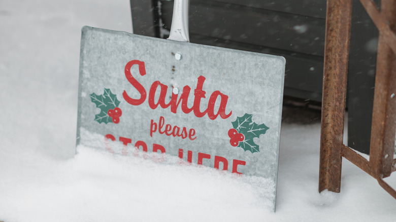 A shovel is painted with a cute Christmas phrase and left outside on the porch as holiday garden decor.