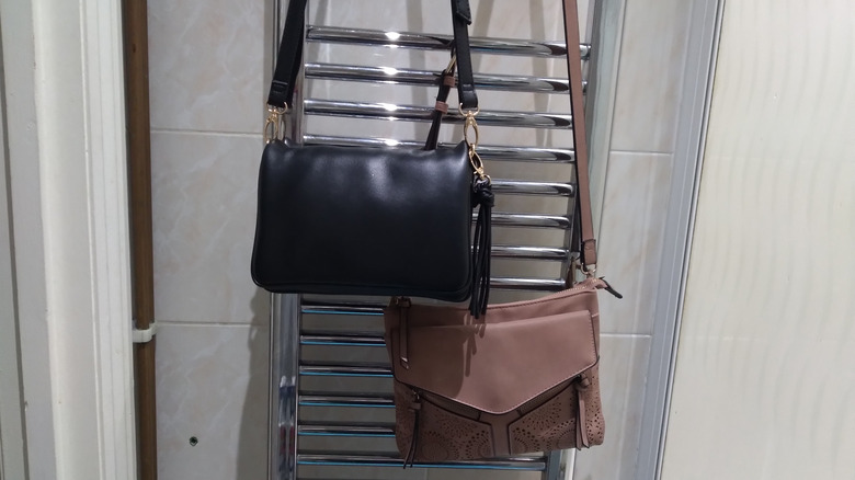 purses hanging on towel rack