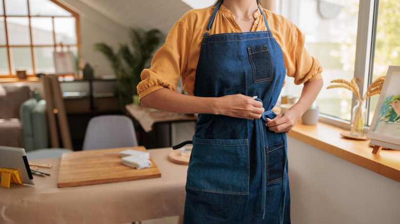 Someone tying an apron around themselves