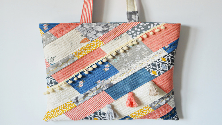 Tote bag incorporating diagonal stripes made from different patterned fabrics.