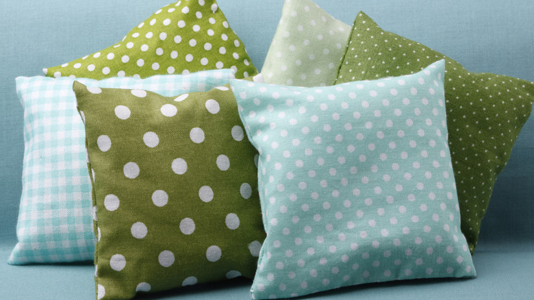 Green and light blue polka-dotted and checked throw pillows.
