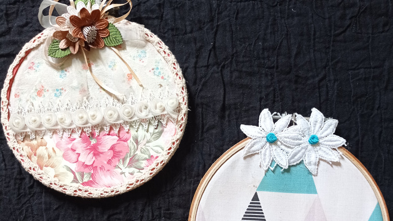 Vintage hankies are affixed inside embroidery hoops decorated with flowers and other fixings to make sweet wall art.