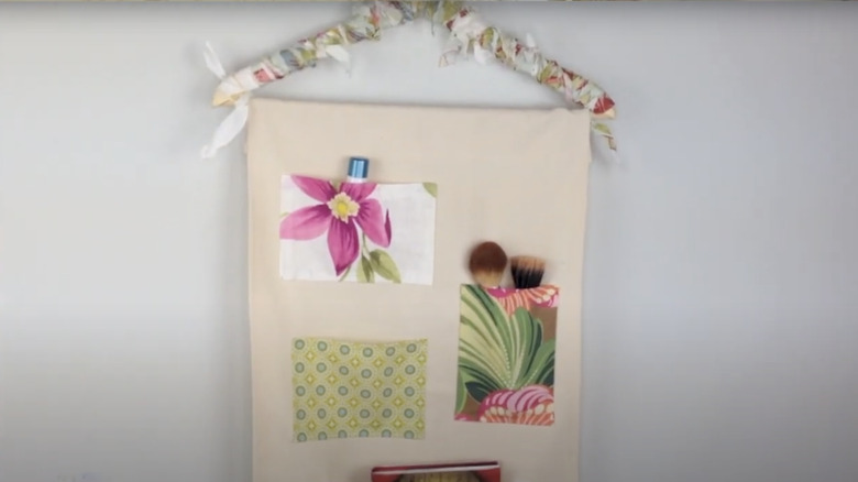 A wall organizer with pockets made from pieces of fabric cut from vintage hankies.