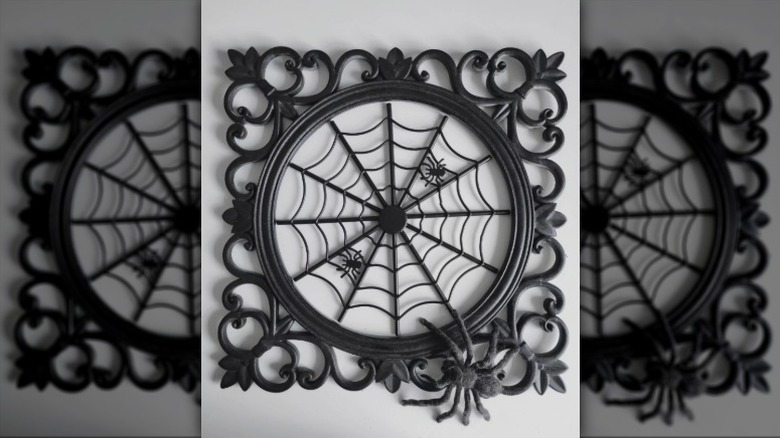 A spiderweb wall hanging made of a vintage trivet frame