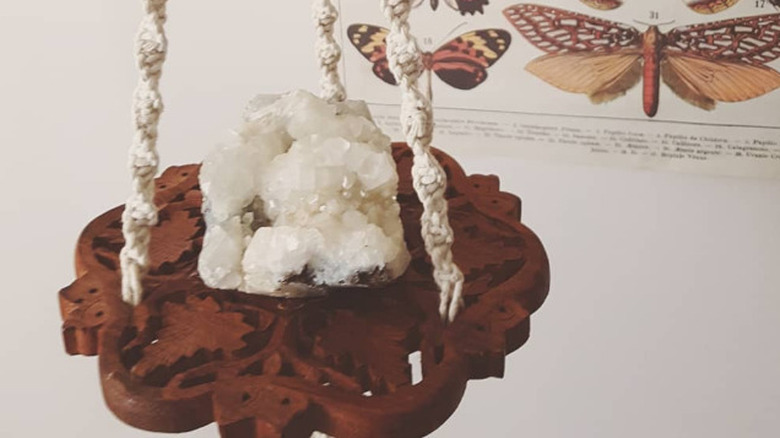 A large crystal hanging on a shelf made from a trivet