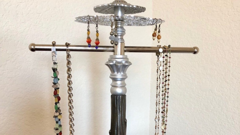 A handmade jewelry holder that includes a repurposed trivet
