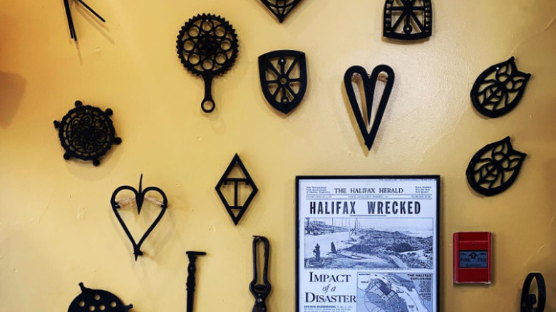 A wall with several vintage trivets mounted on it