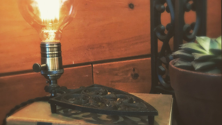 A lamp made out of a cast iron trivet