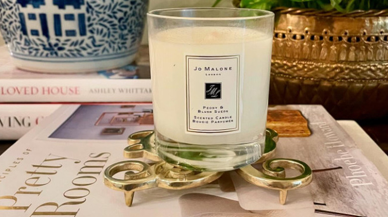 A candle sitting on a metal trivet