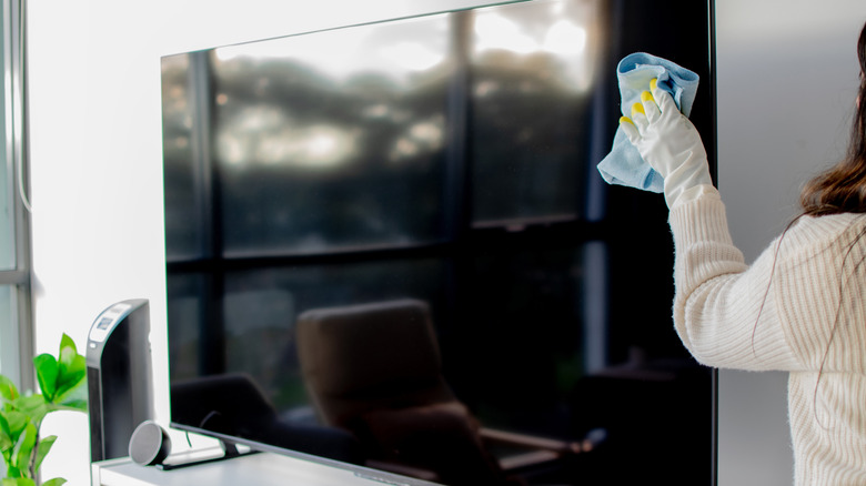 Close up of person dusting TV