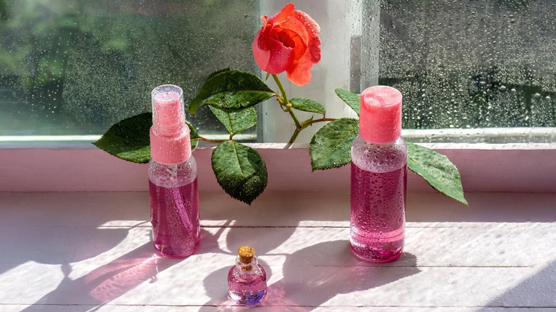 bottles of rosewater on a windowsill