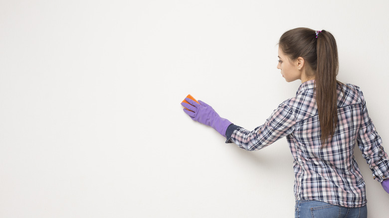 Person wiping down wall