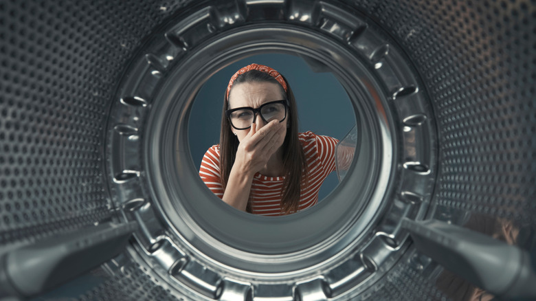 Woman facing dirty washing machine