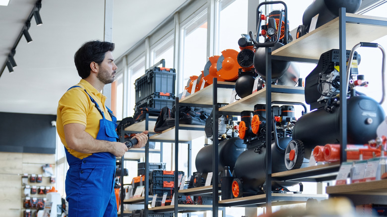 A man checking out expensive tools at the hardware store
