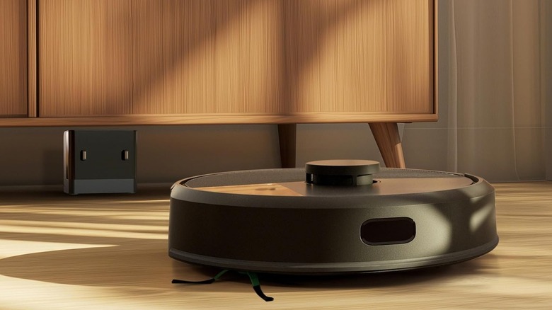 A black robot vacuum on a wood floor