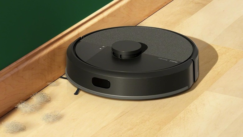 A black robot vacuum near shed fur