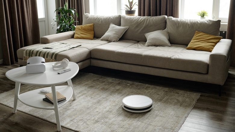 A white robot vacuum on a living room carpet