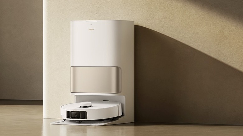 A white and gold robot vacuum in its base