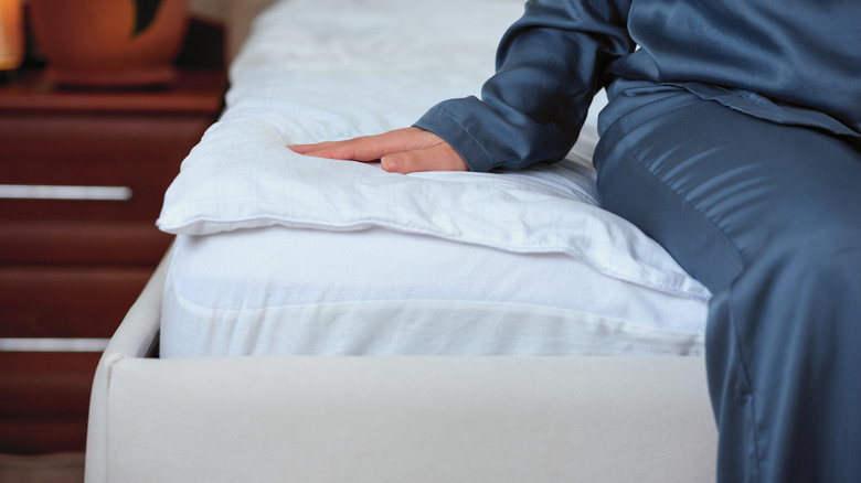 Woman sitting down on the edge of a mattress