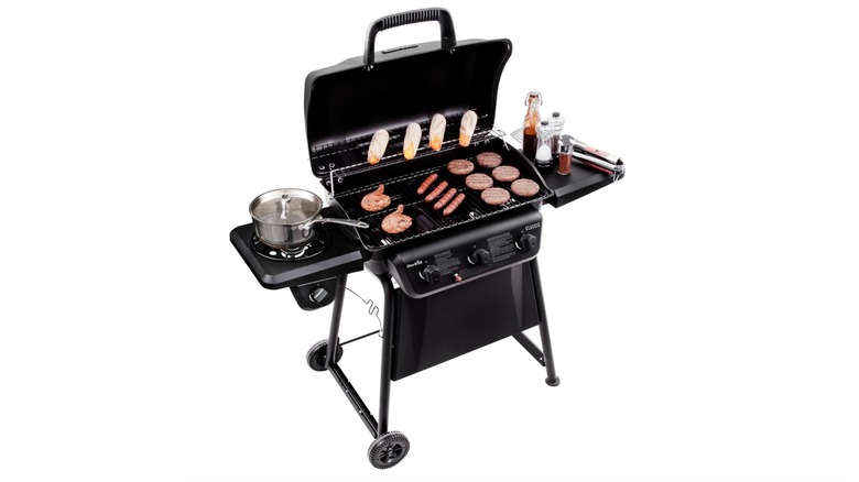 Grill with corn and various meats cooking on top of it