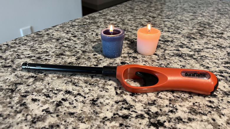 two burning candles with lighter